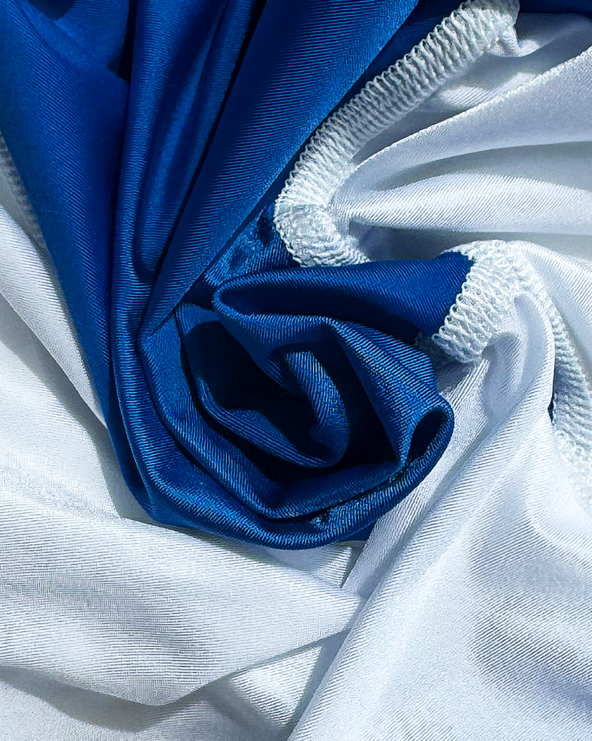 Close-up of soft shiny blue and white lycra with white stitching