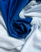 Close-up of soft shiny blue and white lycra with white stitching