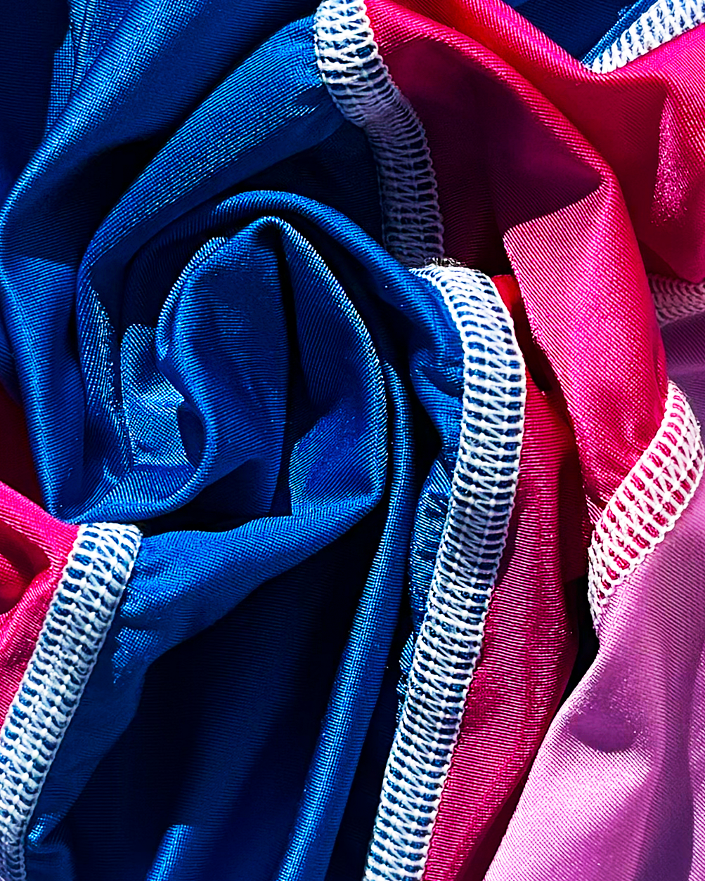 Close-up of blue and pink fabric with white stitching