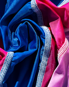 Close-up of blue and pink fabric with white stitching