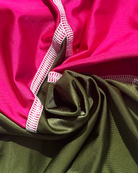 Close-up of pink and green lycra with white stitching.
