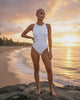 video of woman in white sheer one piece swimsuit at the beach